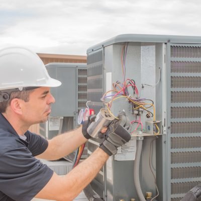 HVAC technician working on a capacitor part for condensing unit.